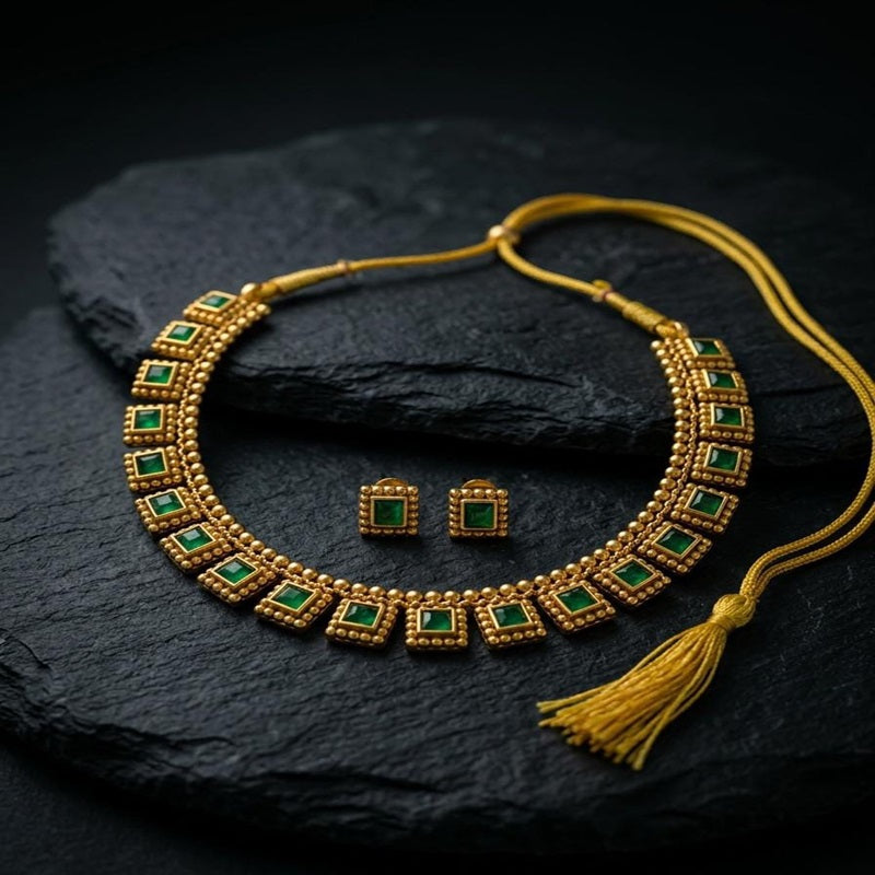 Gold necklace with green gemstones and matching earrings